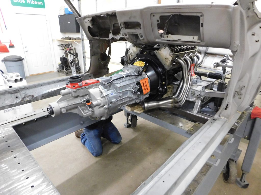 A person working on an engine in a garage.