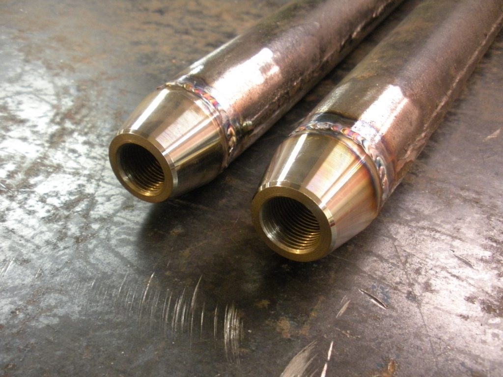 A pair of brass pipes sitting on top of a table.