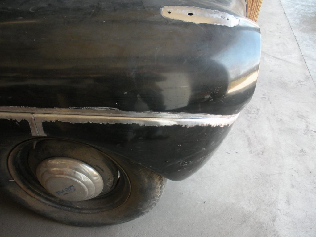 Black car fender with bodywork repair.