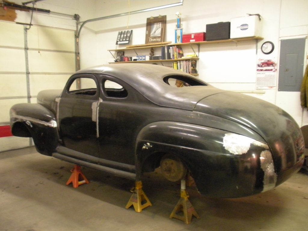 Black classic car body in progress.