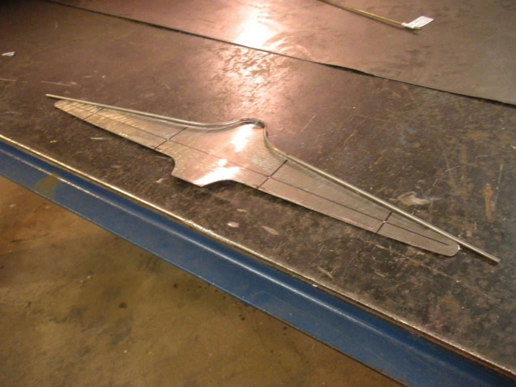 Metal part on workbench, marked for cutting.
