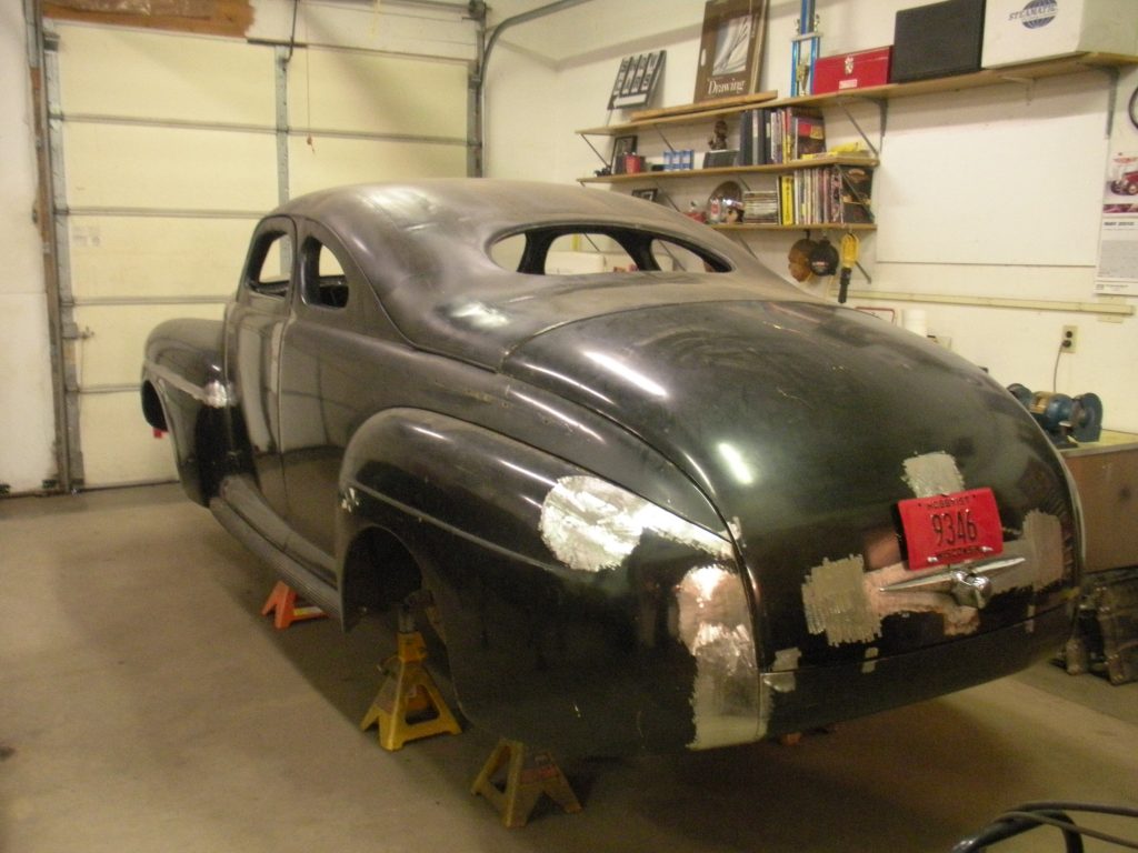 Black classic car body in progress.