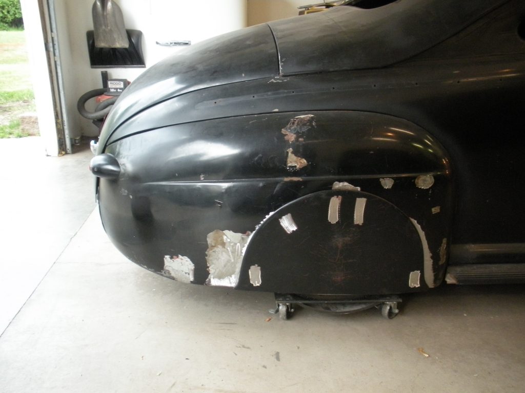 Black classic car, body damage.