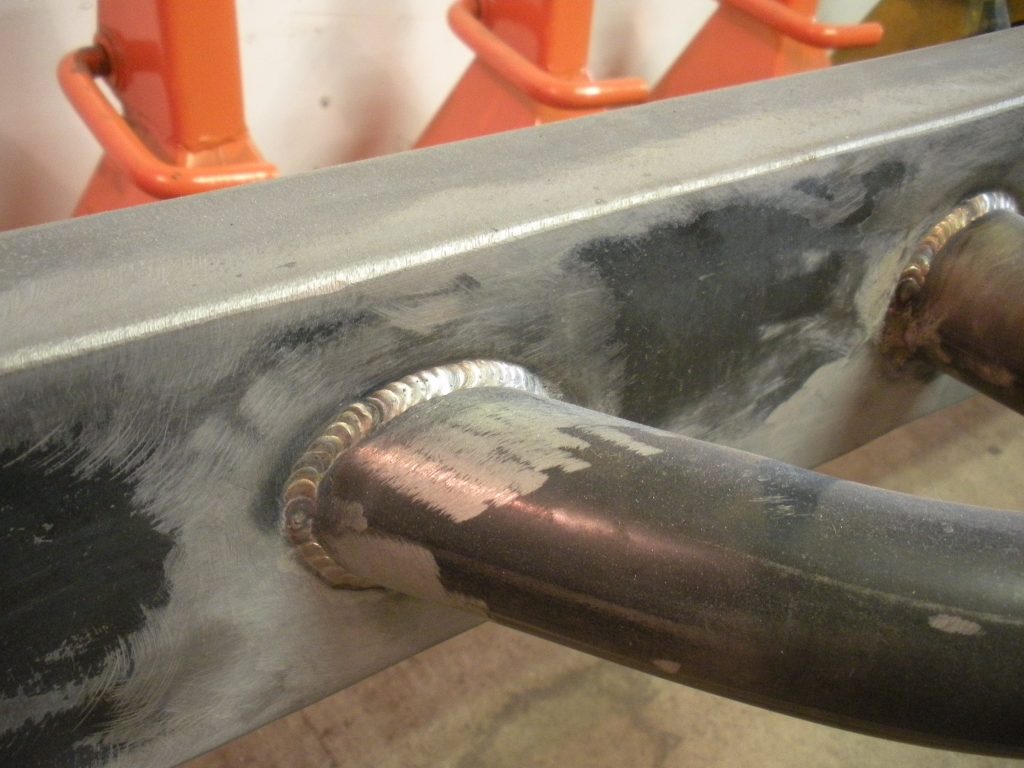A pipe that is being worked on the side of a building.
