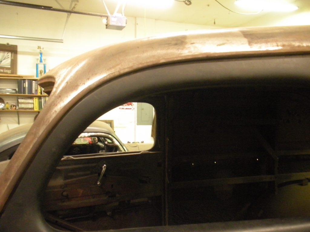 A car is seen in the reflection of its side mirror.
