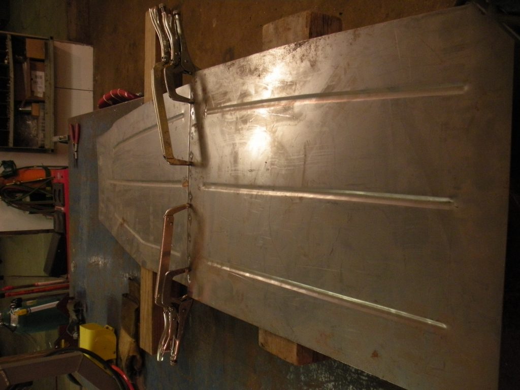 A metal board with two large clamps attached to it.