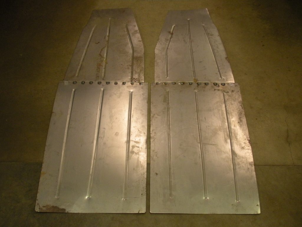 A pair of metal panels sitting on the floor.