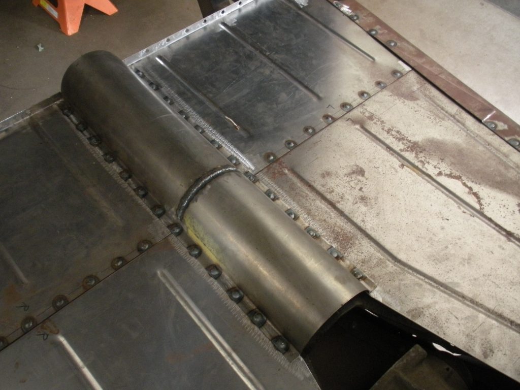 A metal piece of aircraft part is being worked on.