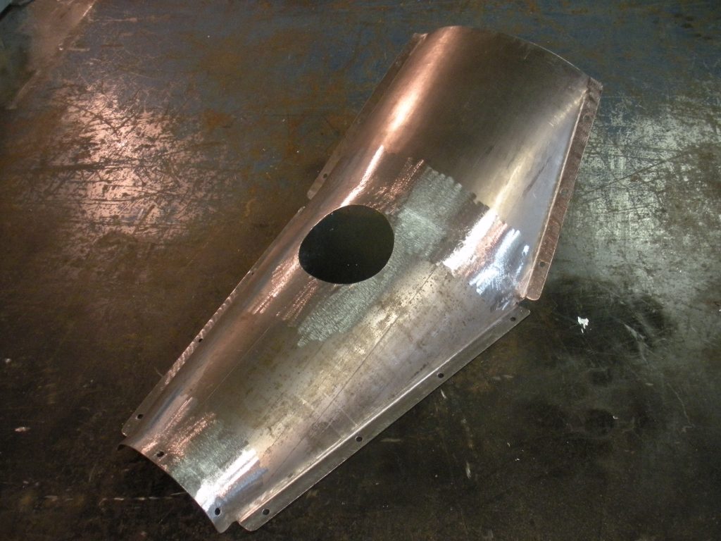 A metal piece of art that is sitting on the ground.