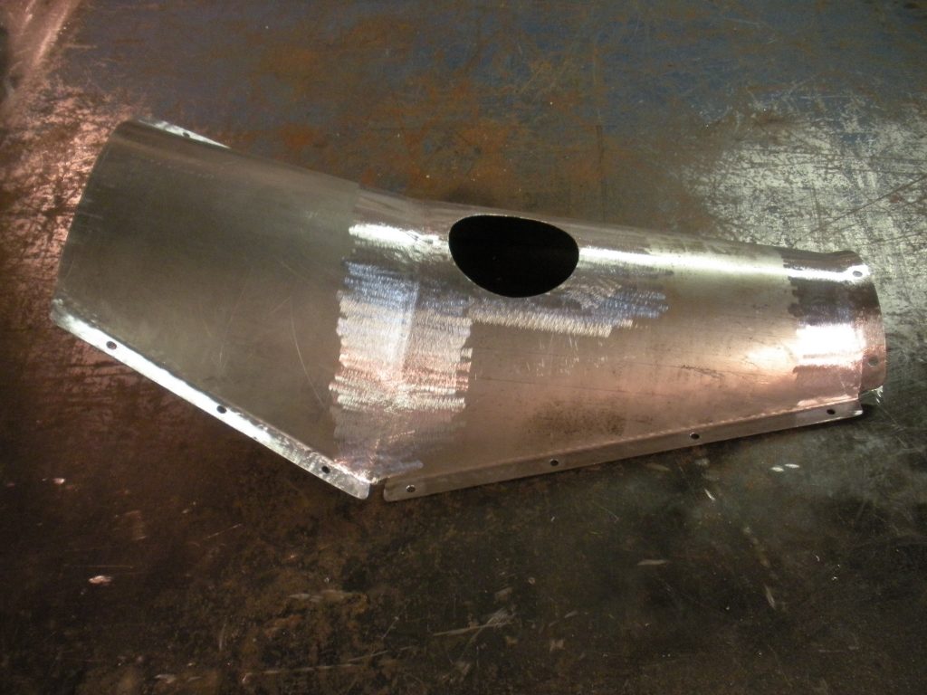A metal piece of art that is sitting on the ground.