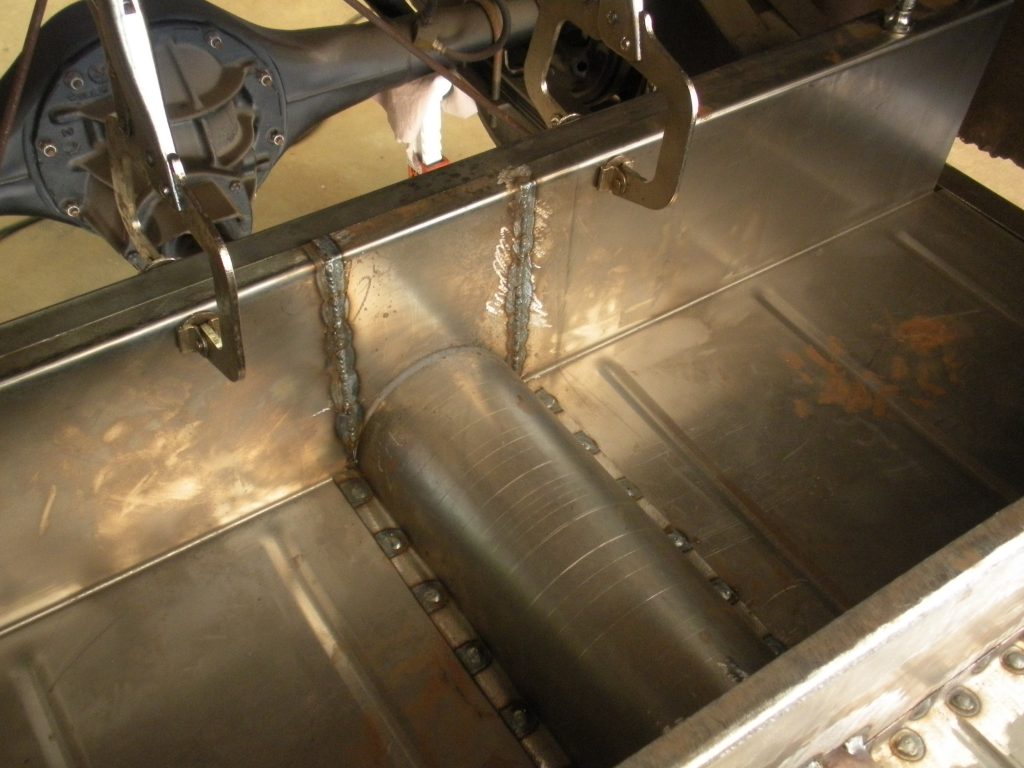 A metal floor with some pipes and wires