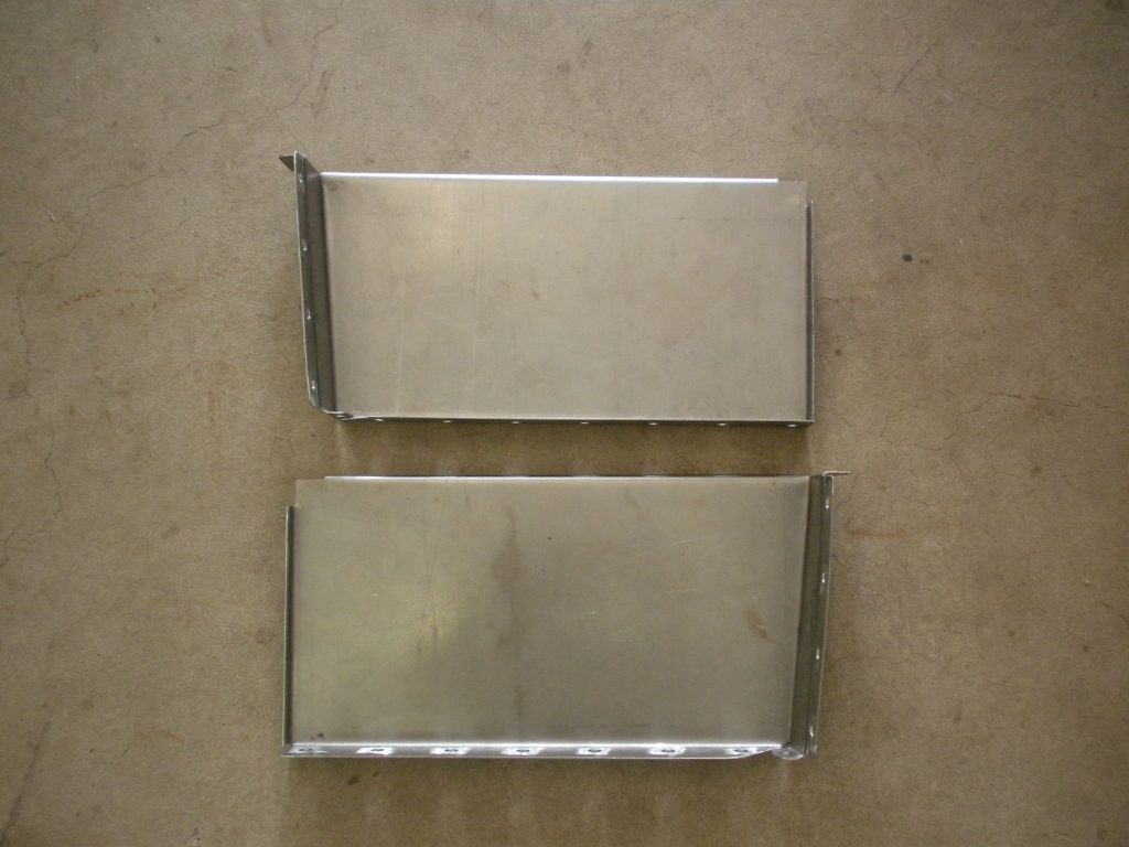 A pair of metal trays sitting on top of a floor.