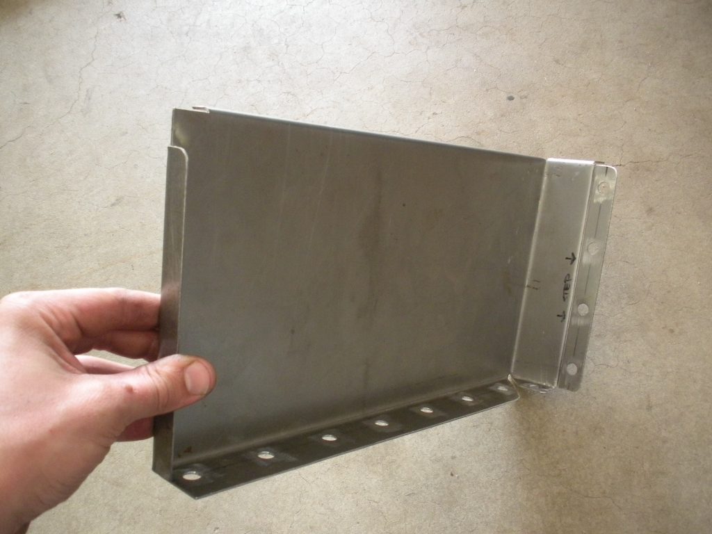 A hand holding an open metal box.