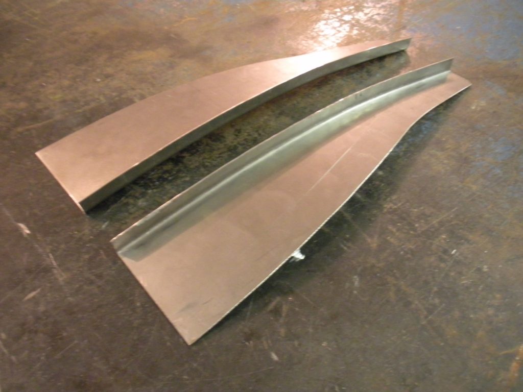A pair of metal pieces sitting on top of the floor.