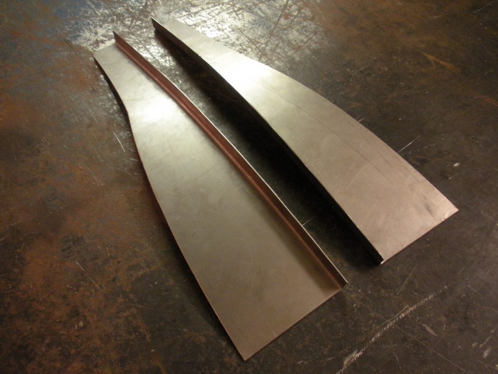 A pair of metal blades sitting on top of the floor.
