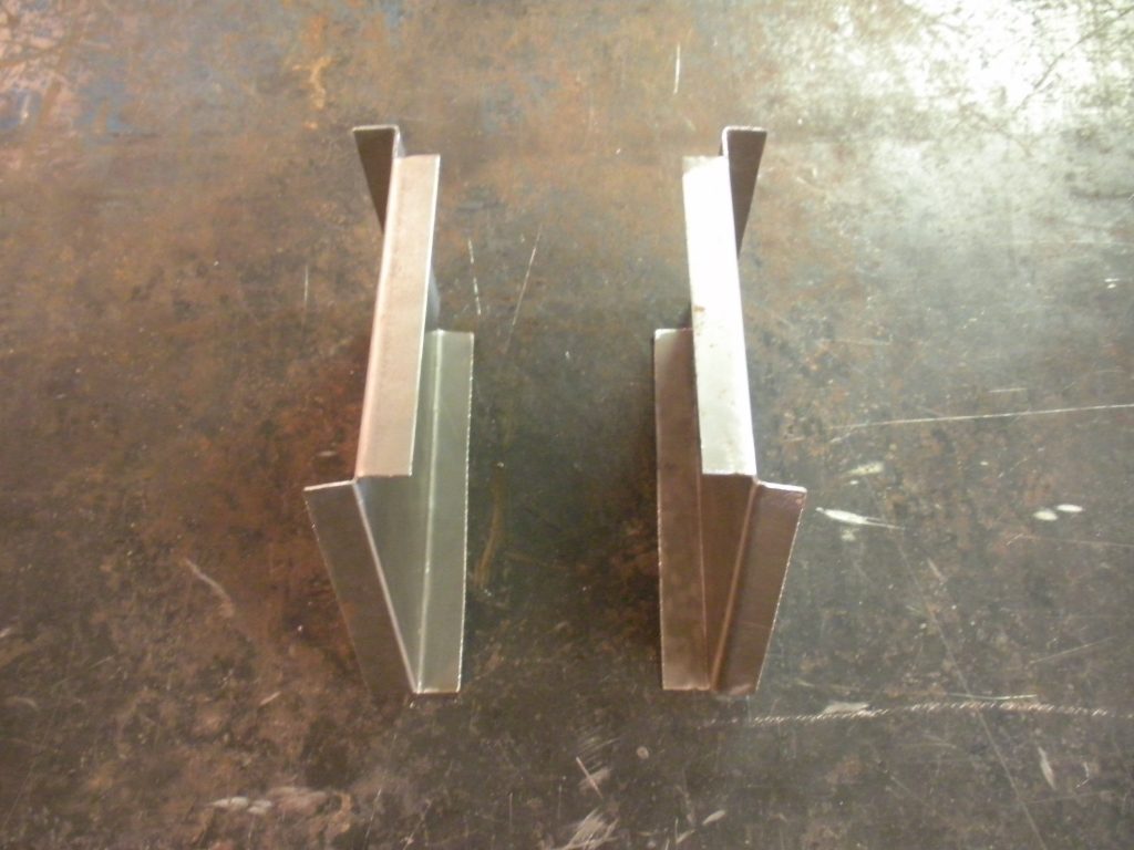 A pair of metal brackets sitting on top of a floor.