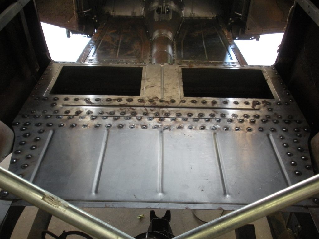 A cat sitting in front of an industrial machine.