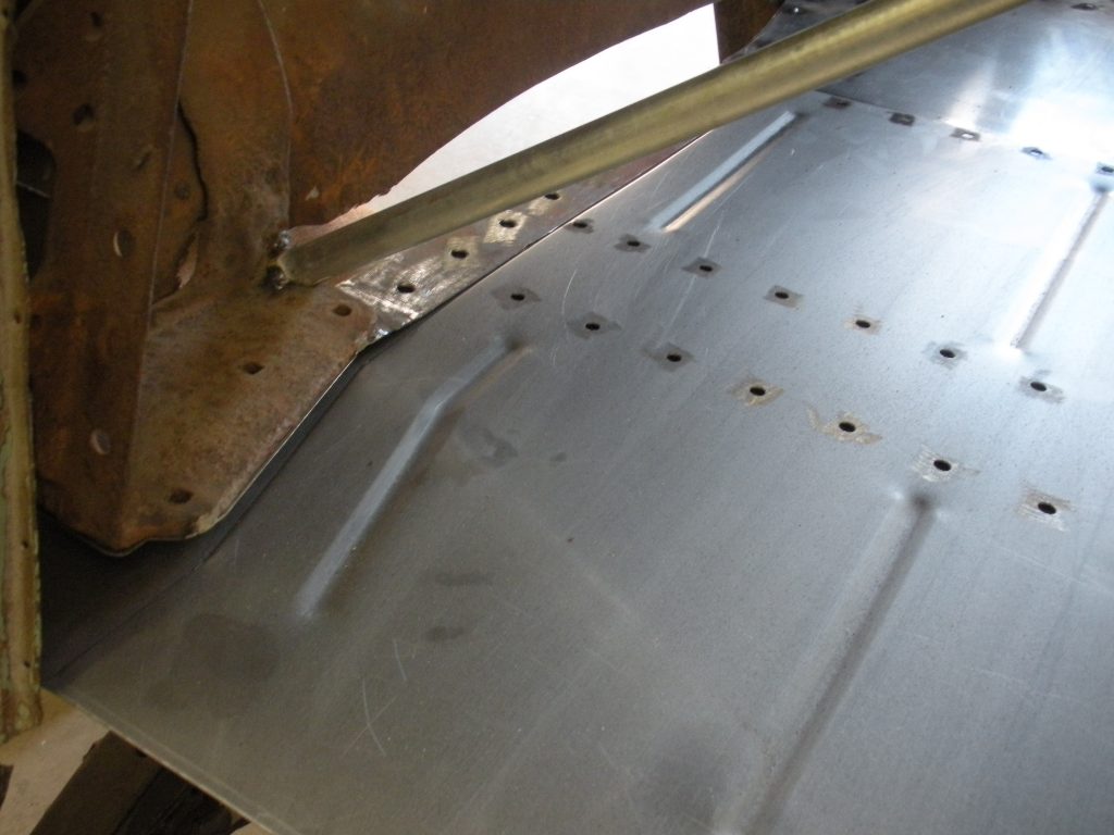 A metal plate with holes in it and some bolts