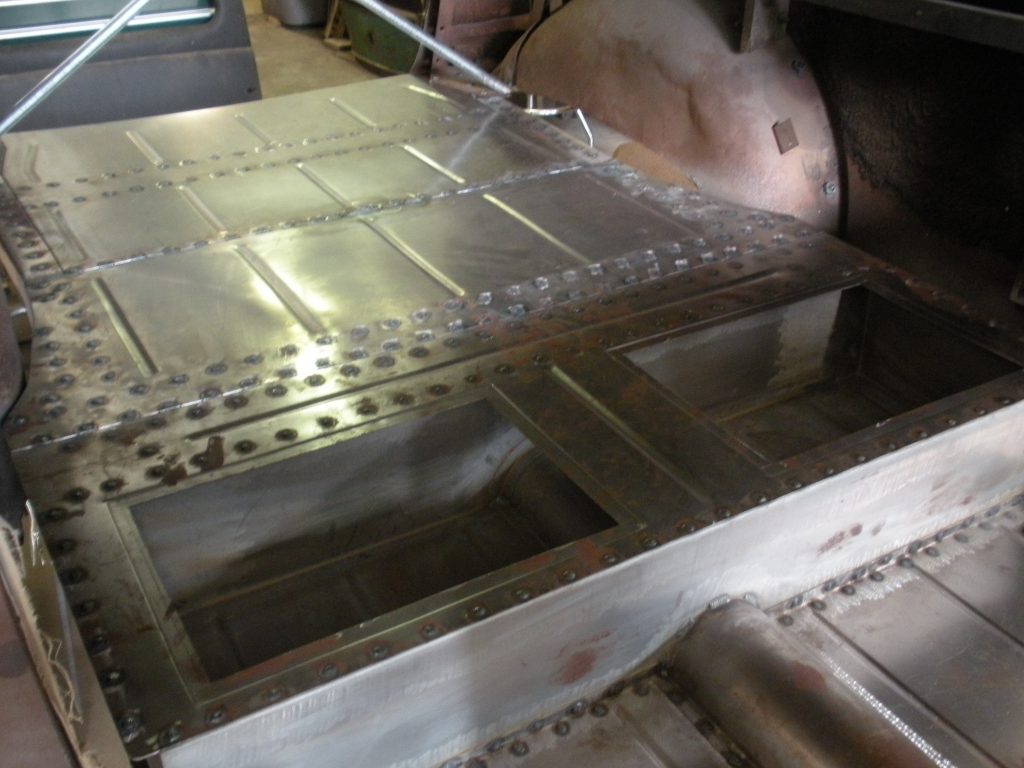A metal piece of art is being worked on.