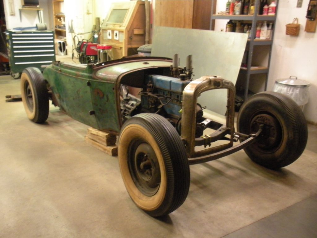 A green car is parked in the garage.