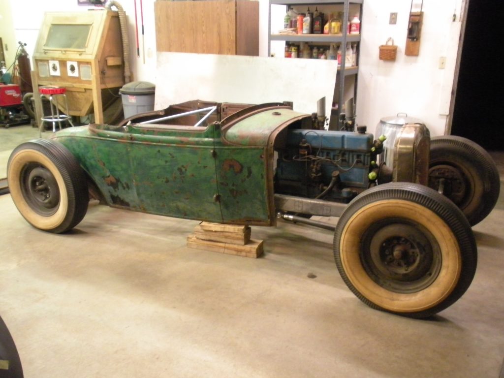 A green car is parked in the garage.