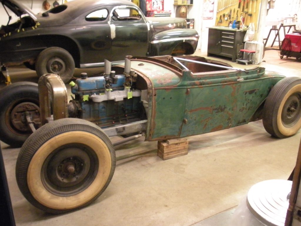 A green car is parked in the garage