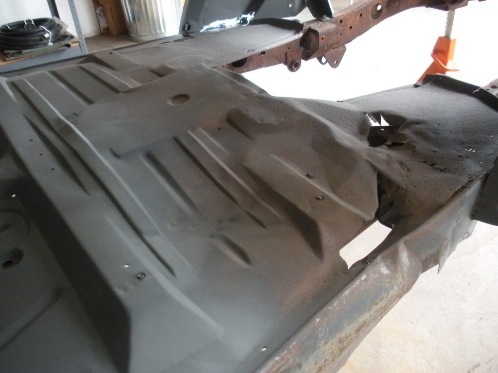 A man is working on the bottom of a car.