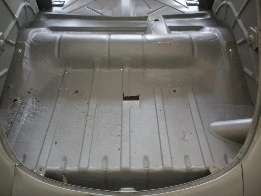 A silver car with the floor exposed.