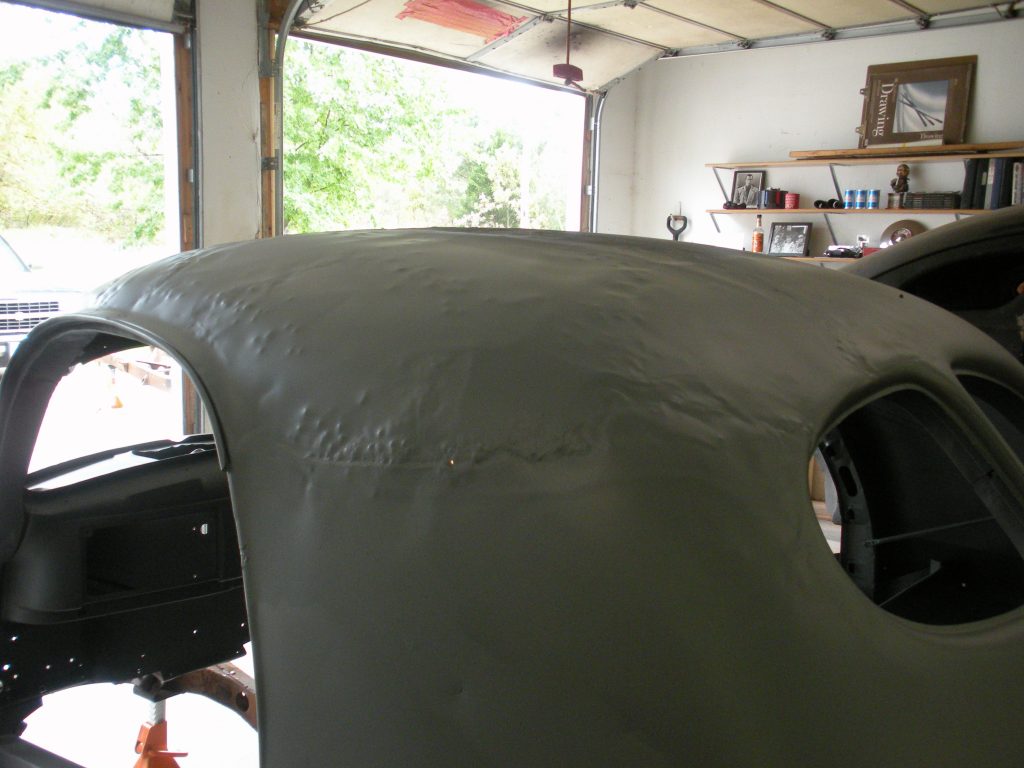 A car is being painted in the garage.