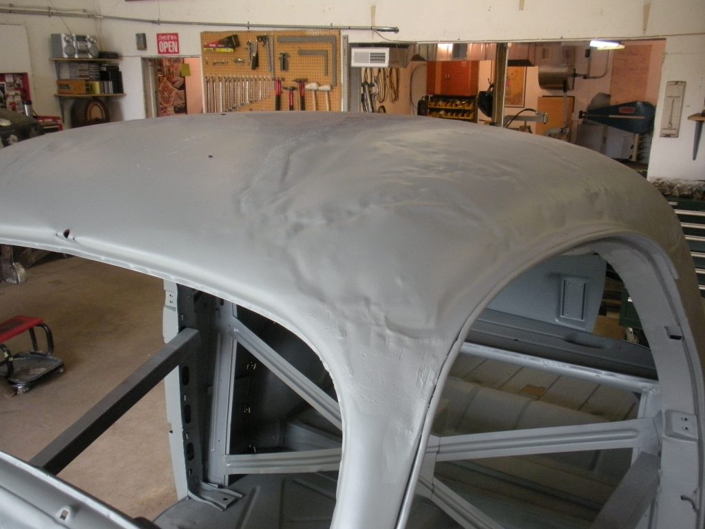 A white car hood is being worked on.