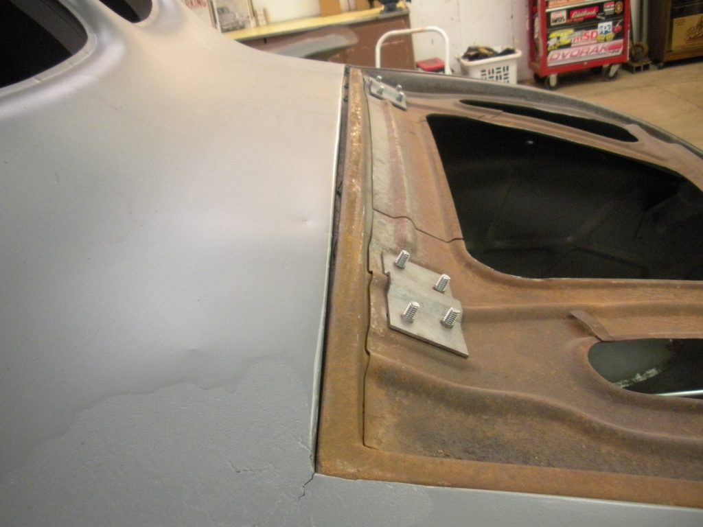 A car door is open and the window has been broken.