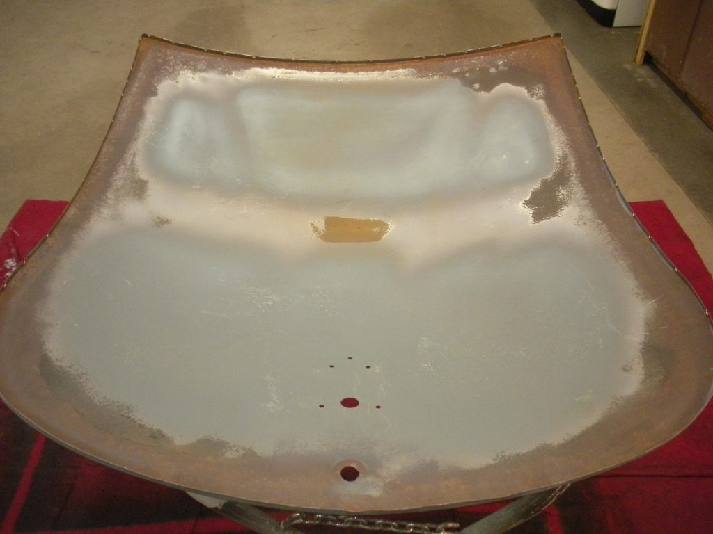 A white tub with brown rim and some paint on it