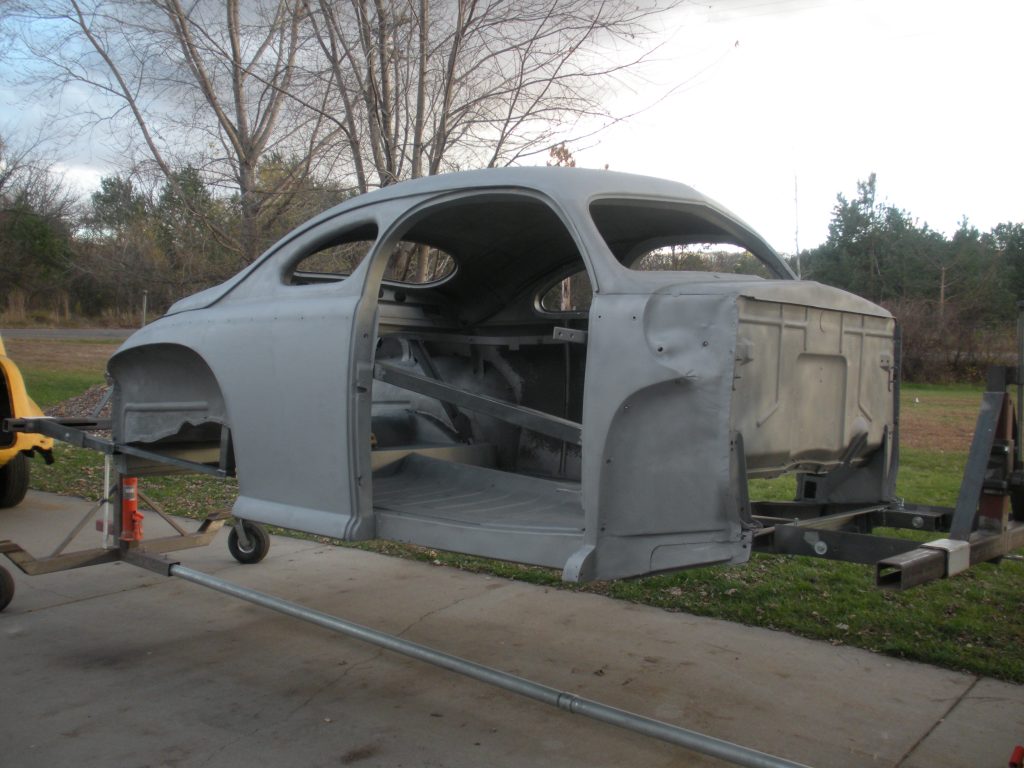Gray car body shell on a dolly.