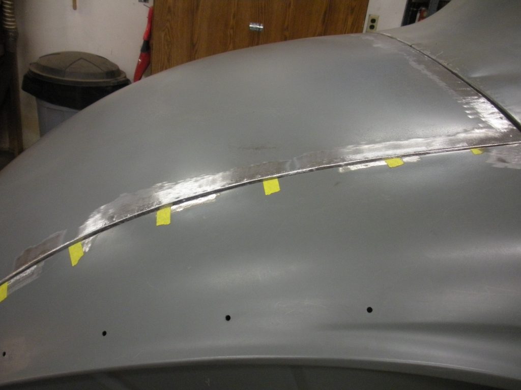 A car is being painted with yellow tape.