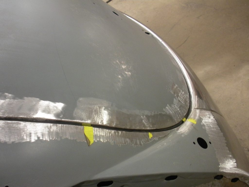 A car with yellow paint on it's hood.