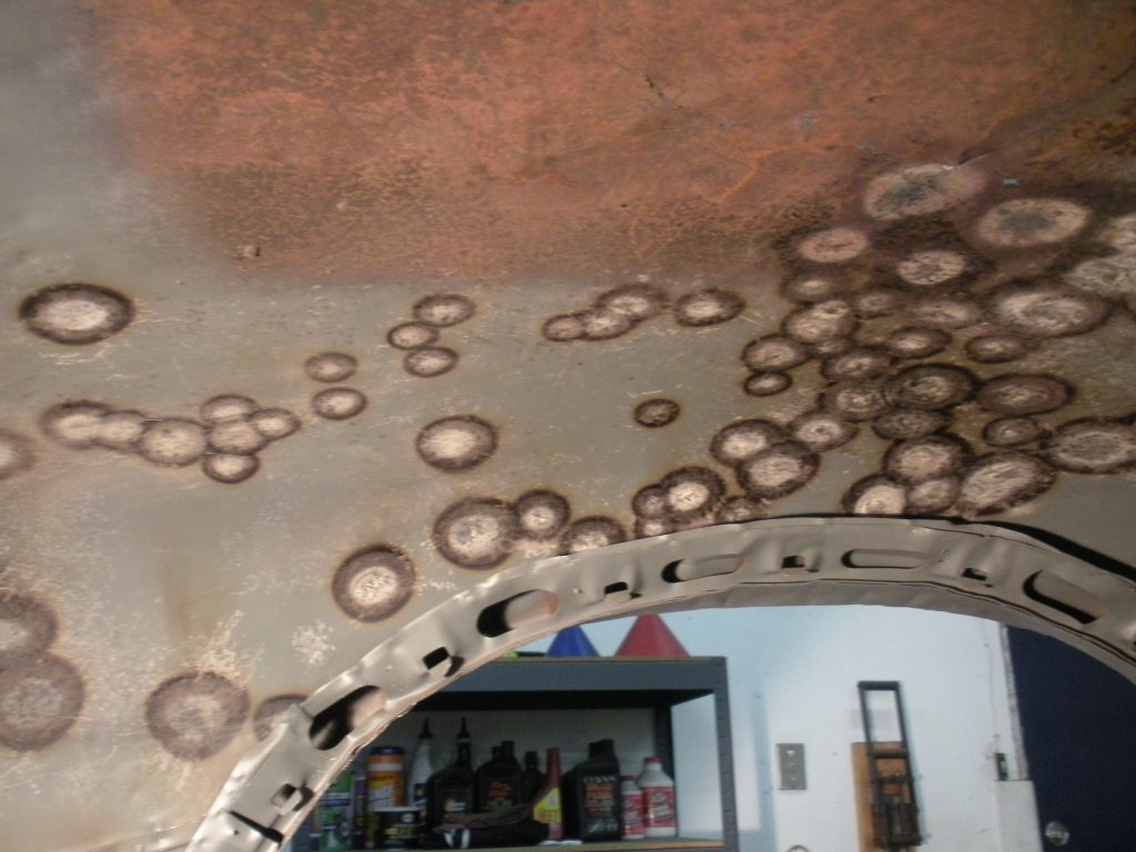 A room with a ceiling that has some brown and white circles on it
