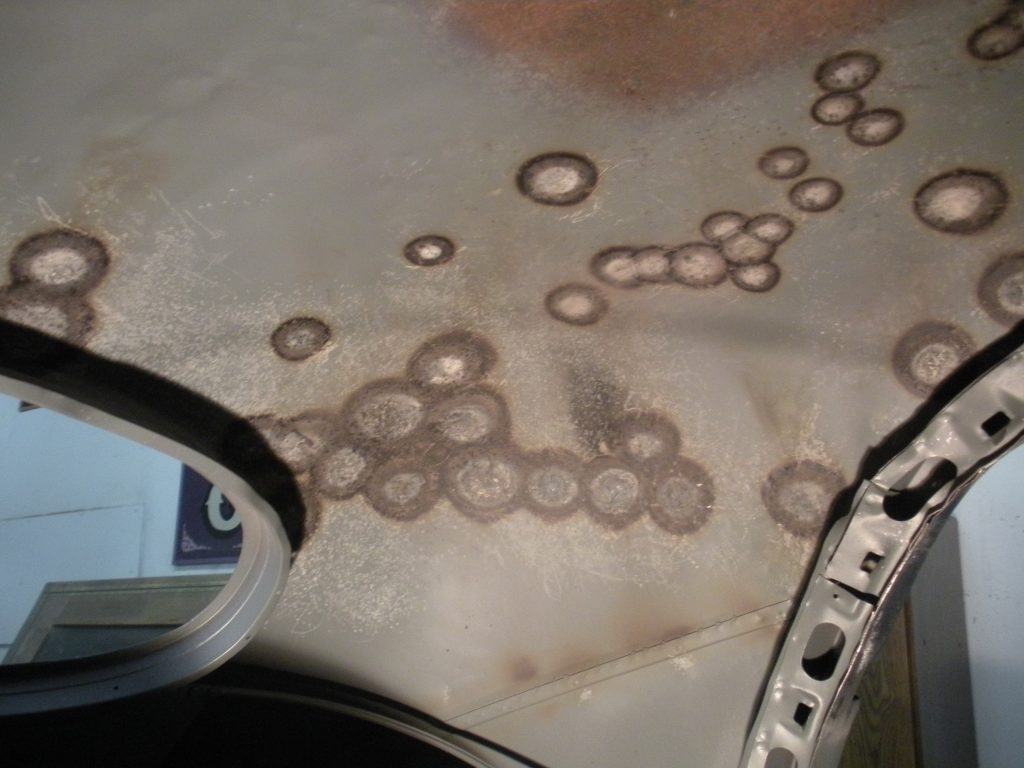 A car mirror with some brown spots on it