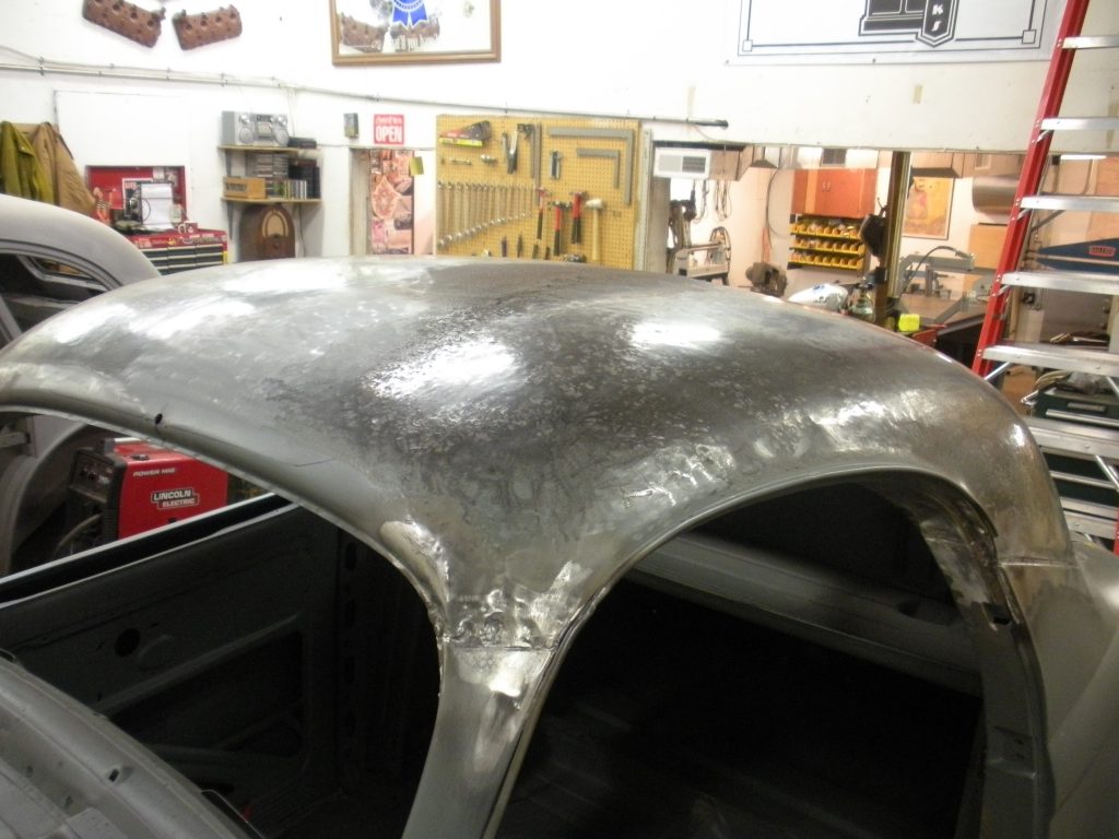 A car hood is being worked on in the shop.