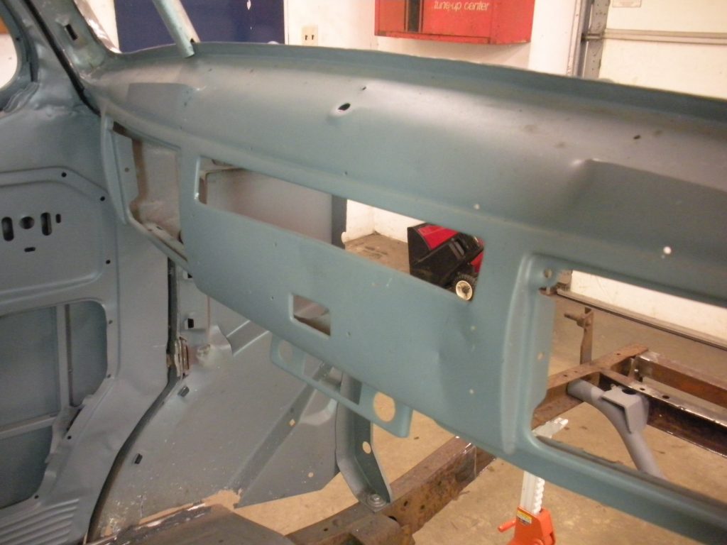 A blue car is being worked on by an engineer.