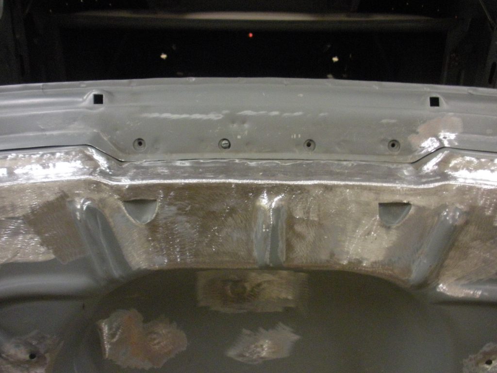 A car hood is being cleaned and polished.