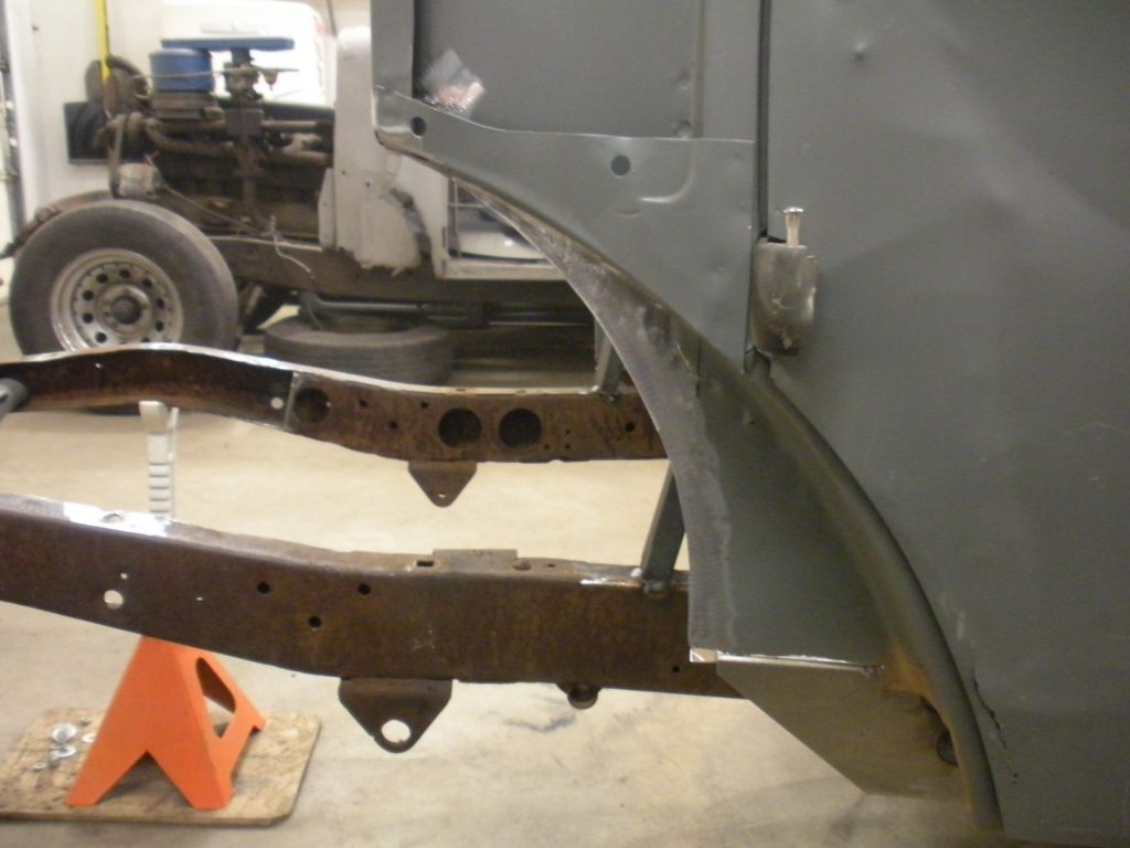 A truck is being worked on in the garage.