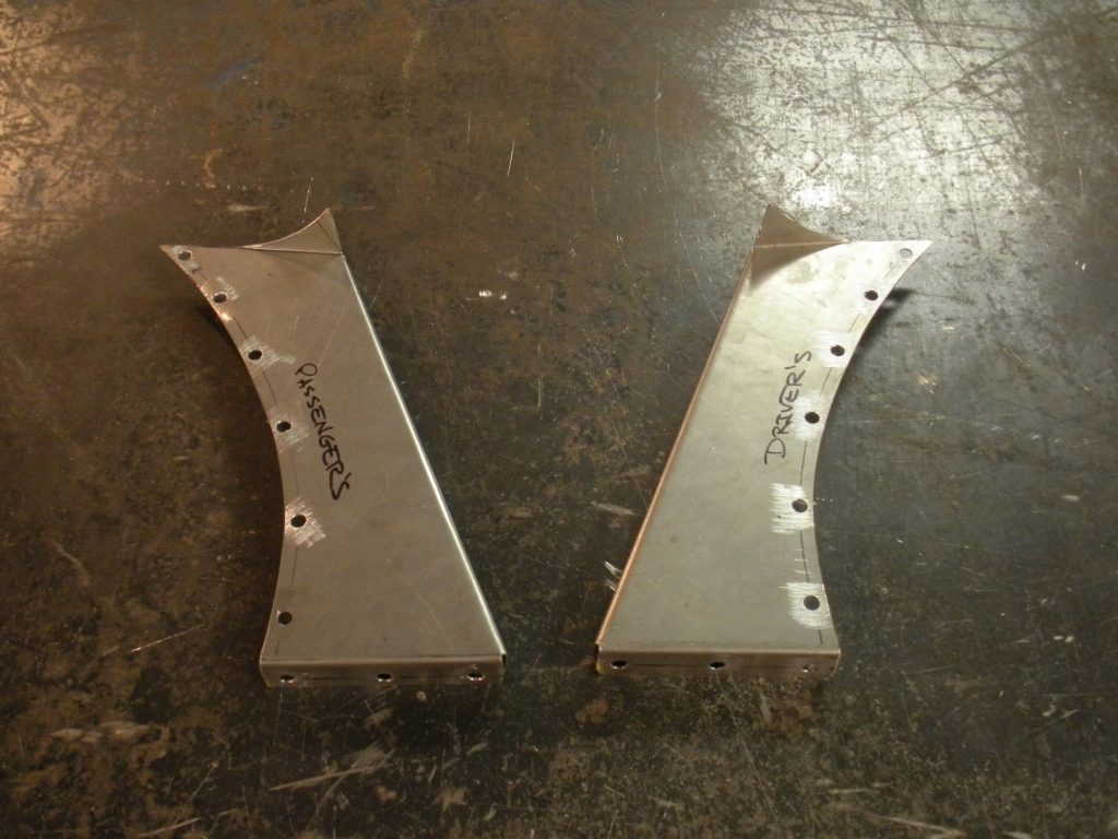A pair of metal parts sitting on top of a floor.