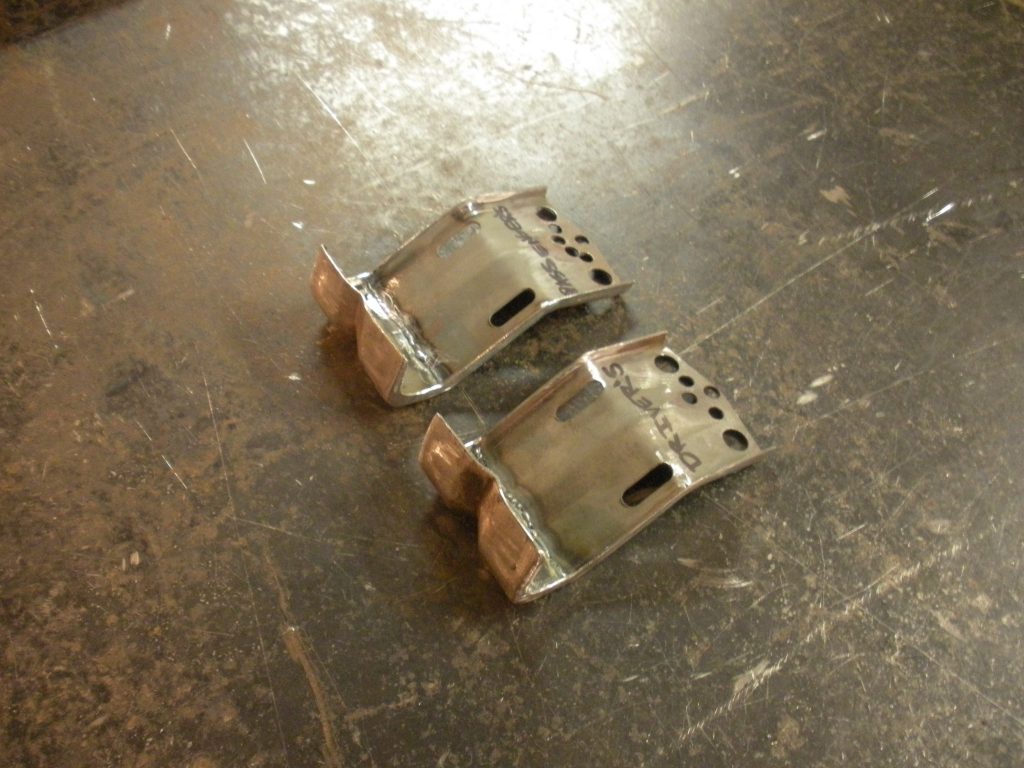 A pair of metal brackets sitting on top of the floor.