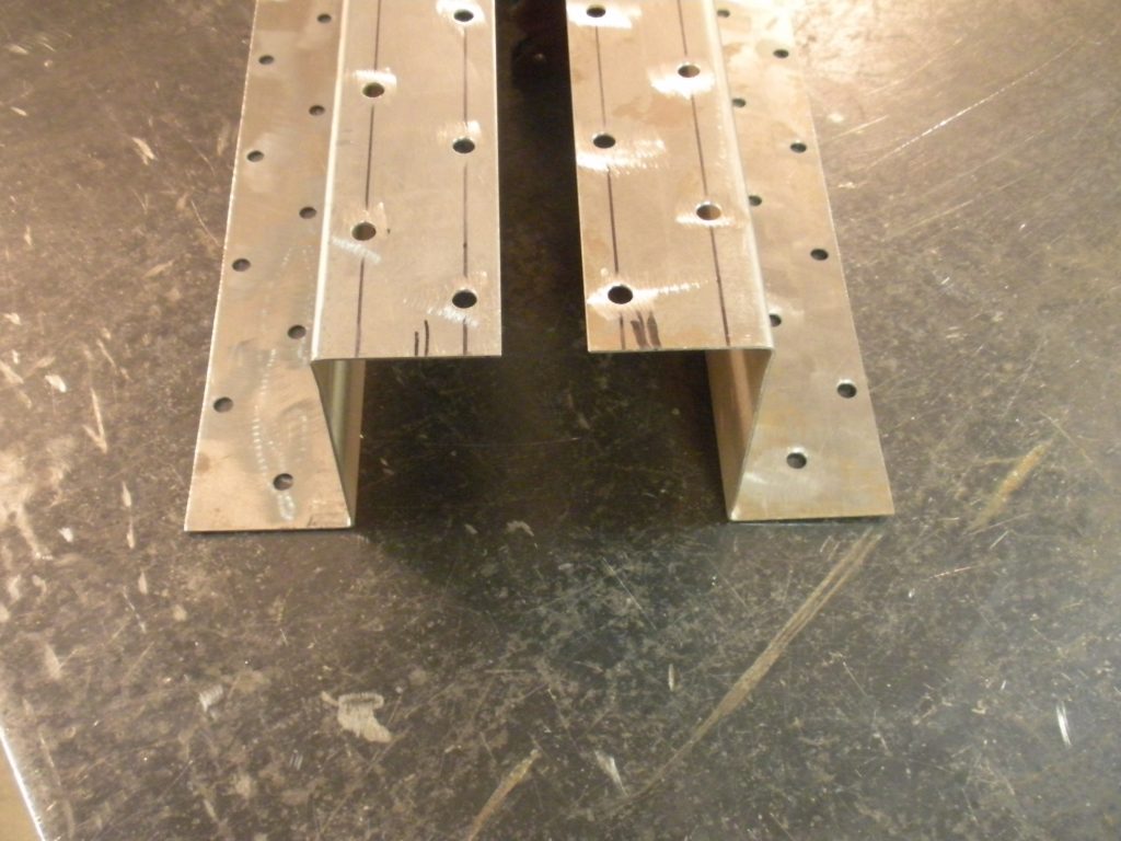 A bench that is made of metal and has holes.