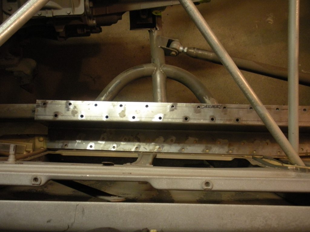 A metal frame with holes in it for the bottom of the car.