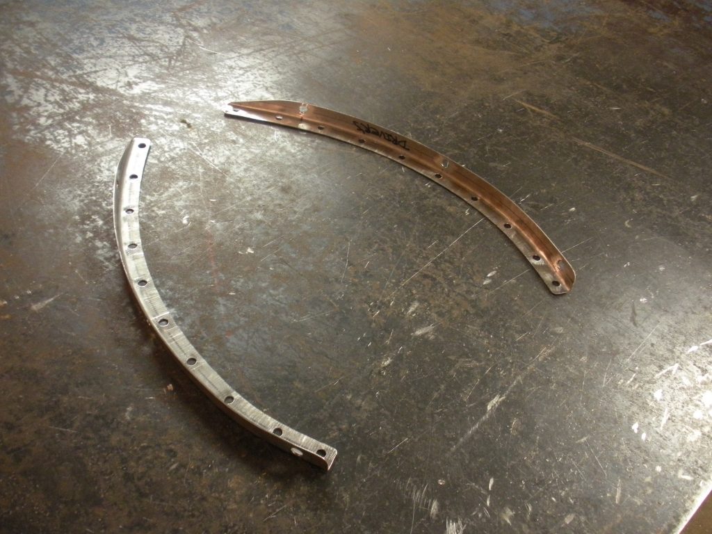 A pair of bent metal pieces on the floor.