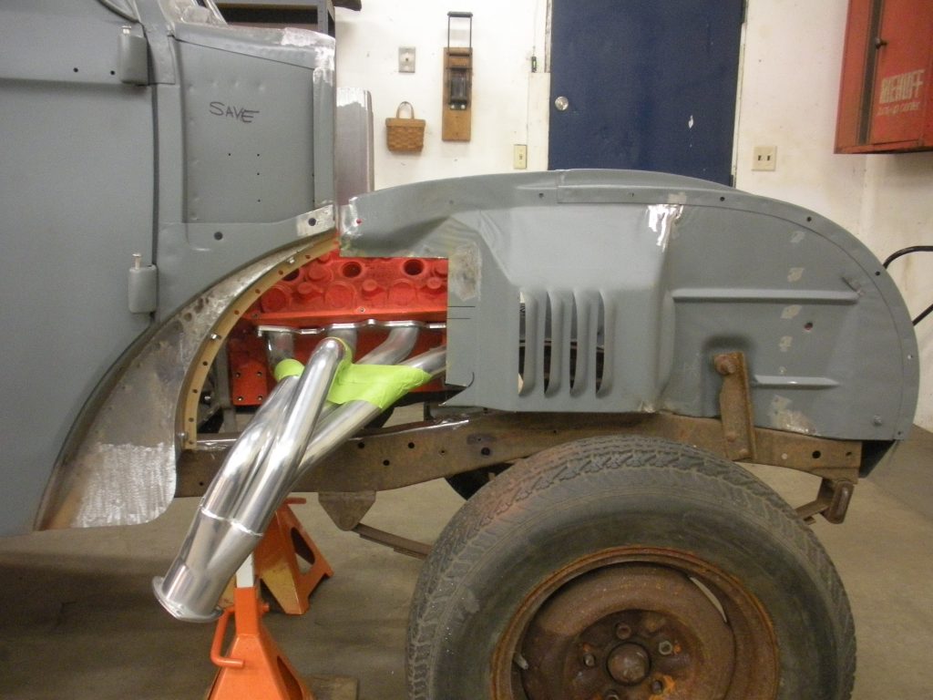 A truck is being worked on in the garage.
