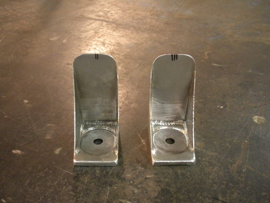 A pair of metal brackets sitting on top of the floor.