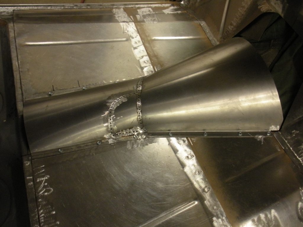 A metal pipe with water running through it.