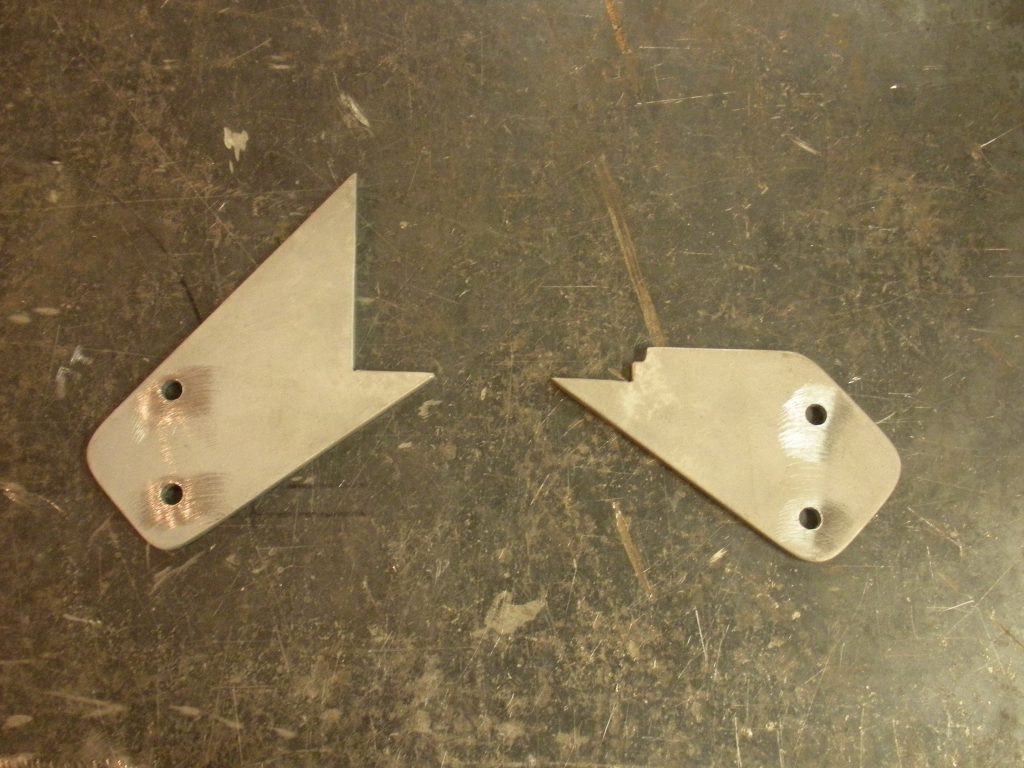 A pair of metal pieces that are missing some parts.